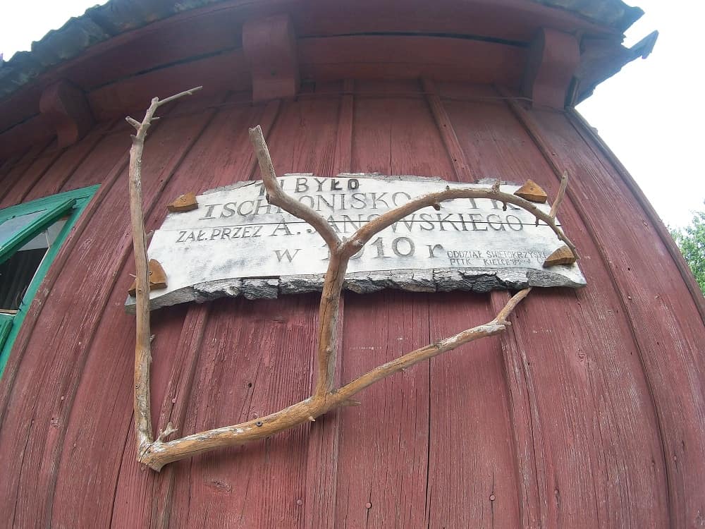 Na drewnianej ścianie tablica też drewniana obwieszczająca, że było tu pierwsze schronisko w Górach Świętokrzyskich