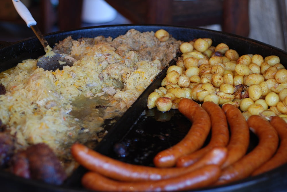 Kapusta, ziemniaki, golonka, kiełbasy, wszystko ciągle podgrzewane na patelni.