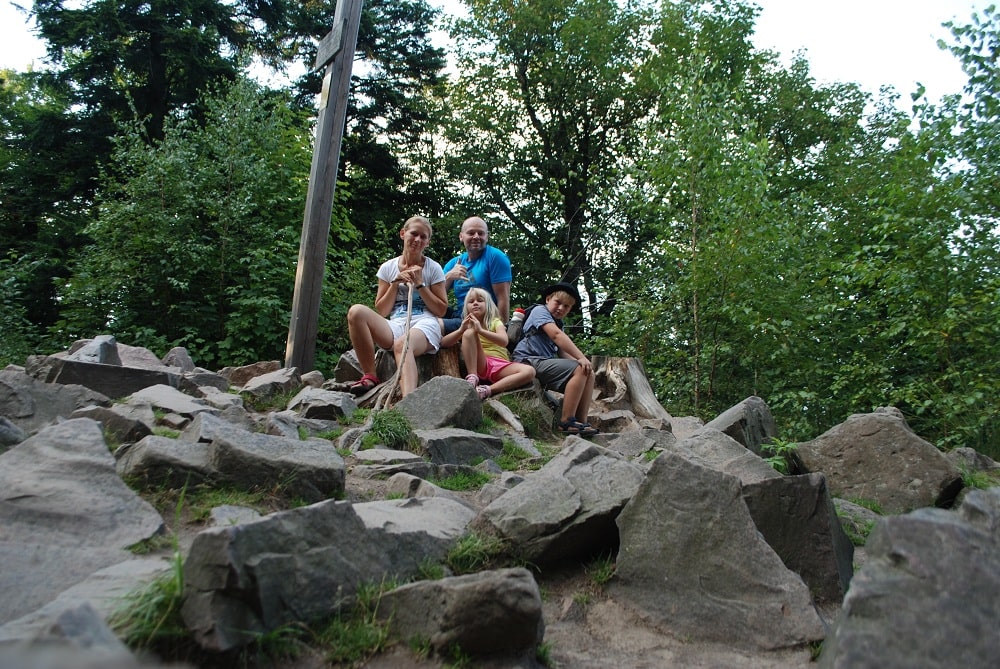 Rodzina siedzi na kamieniach na szczycie Łysicy.
