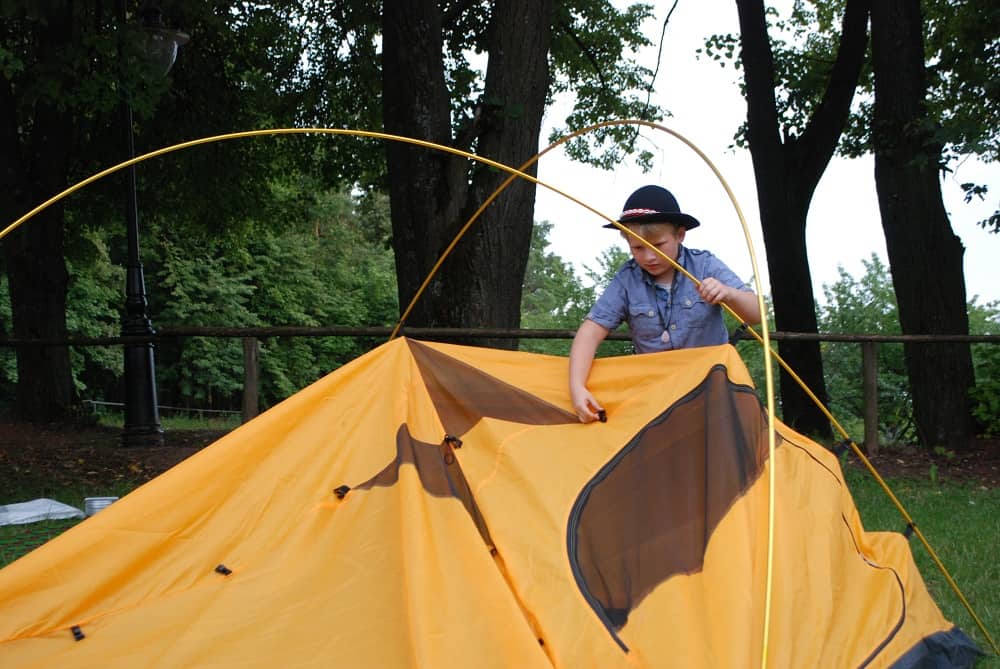 Jasiu w kapeluszu buduje schronienie (namiot) na kolejne noce.
