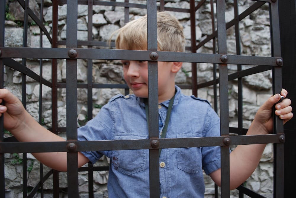 Chłopiec w metalowej klatce.