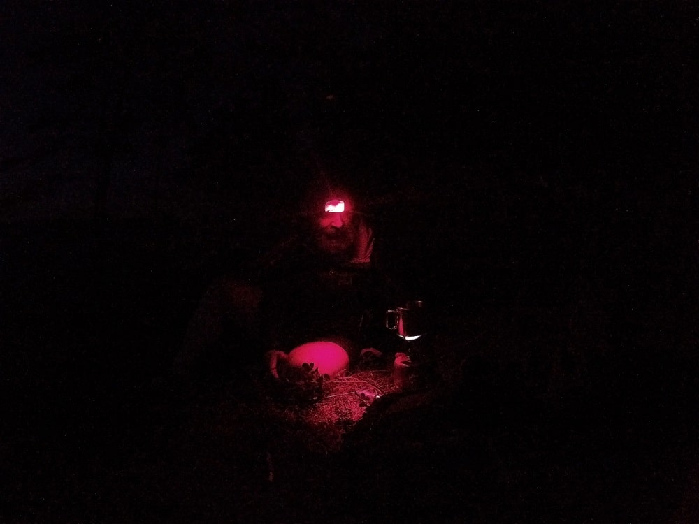 W ciemności rysuje się postać przy palniku. Najwyraźniej oczekuje gorącej wody która jest podstawą szybkich biwakowych potraw.