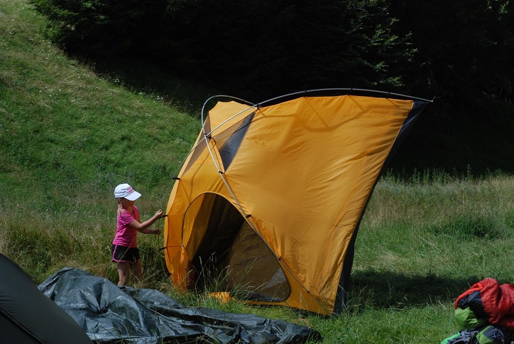 Zuzanna przechyla sypialnie namiotu Andy IV firmy Fjord Nansen żeby wysypać piach z sypialni. Sypialnia koloru żółtego.